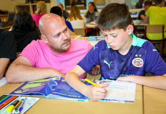 Meester geeft uitleg aan leerling